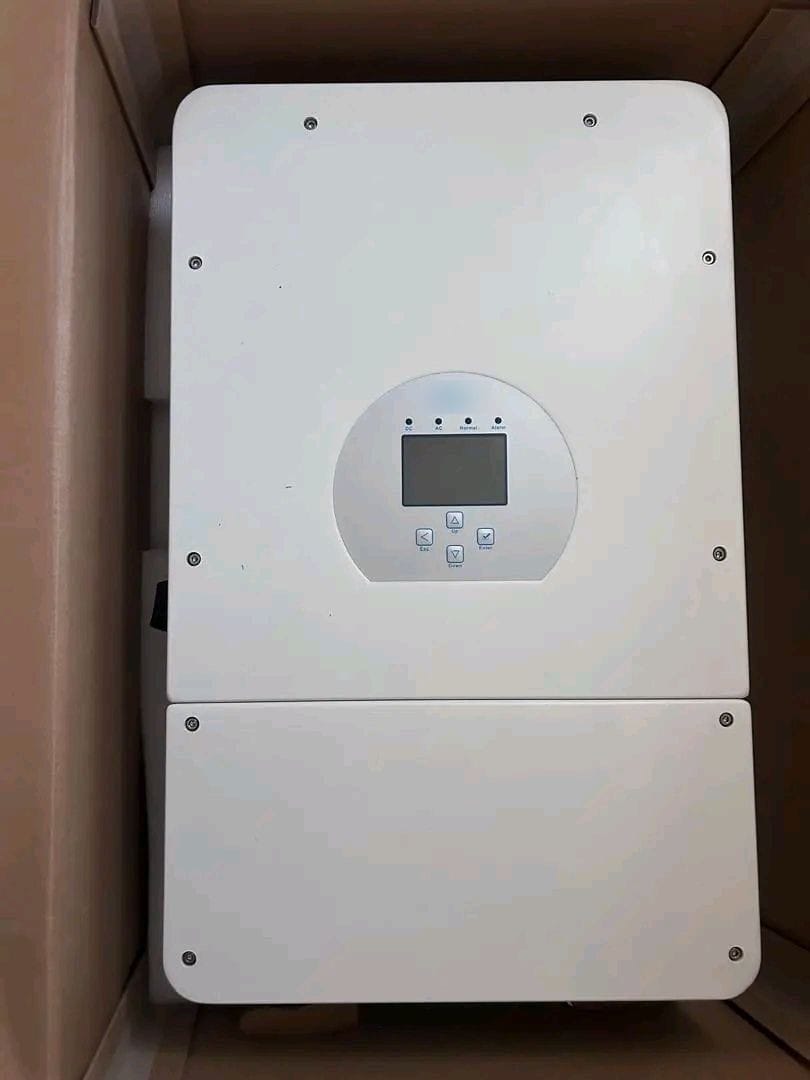 A white hybrid inverter with a display and buttons, still inside its cardboard box